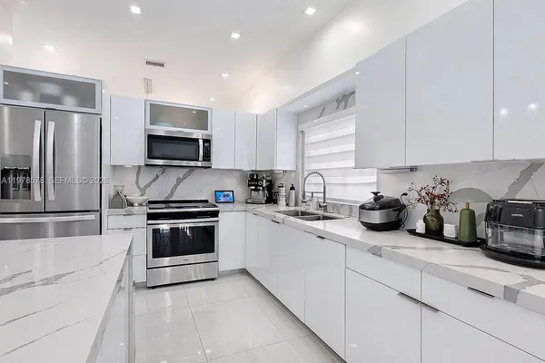 a large kitchen with stainless steel appliances granite countertop a stove and a sink