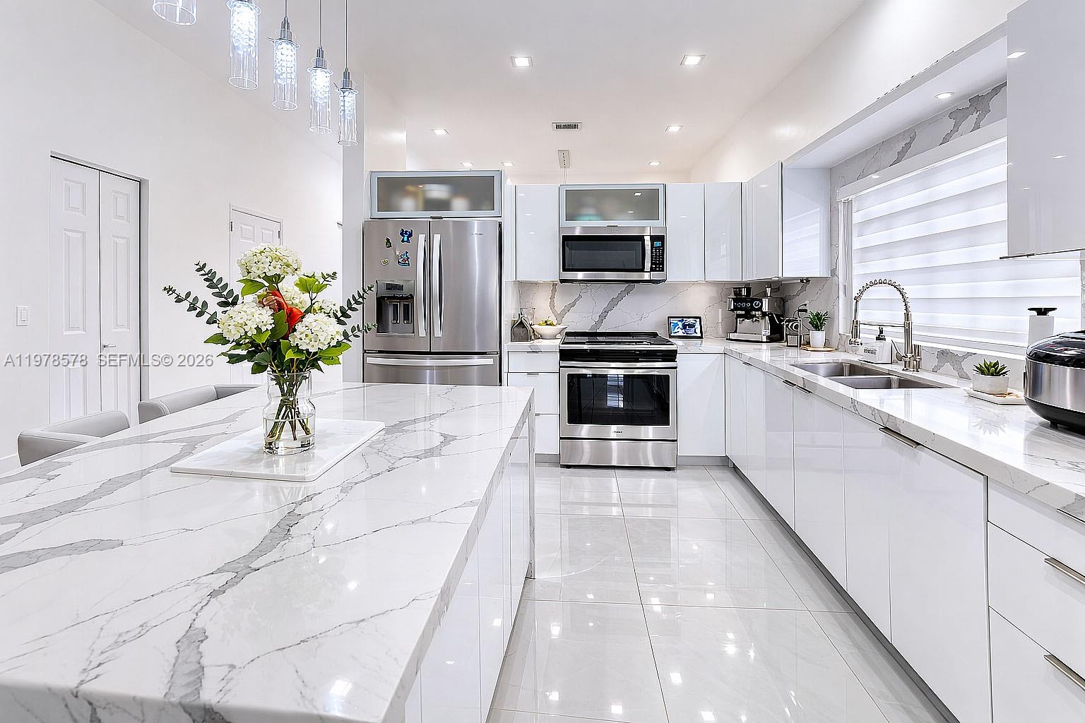 3502 Southwest 156th Court Miami, FL 33185 - Photo 27 of 47 a kitchen with stainless steel appliances kitchen island granite countertop a sink a stove top oven a refrigerator cabinets a dining table and chairs