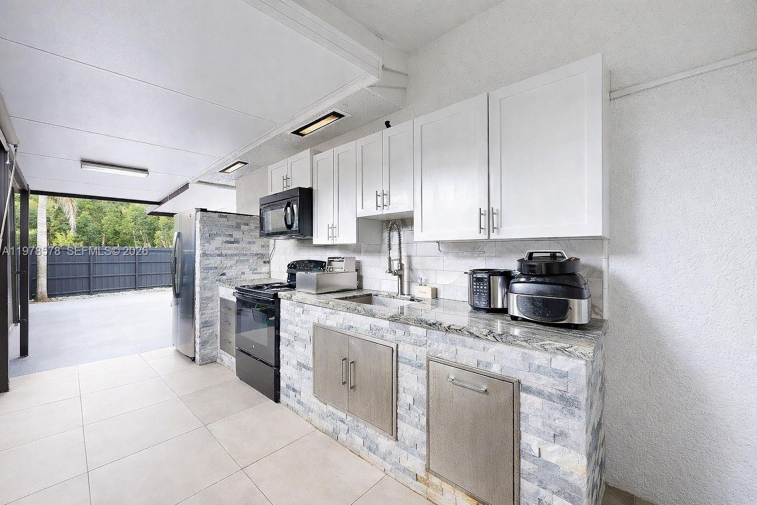 3502 Southwest 156th Court Miami, FL 33185 - Photo 34 of 47 a kitchen with stainless steel appliances granite countertop a stove sink and cabinets