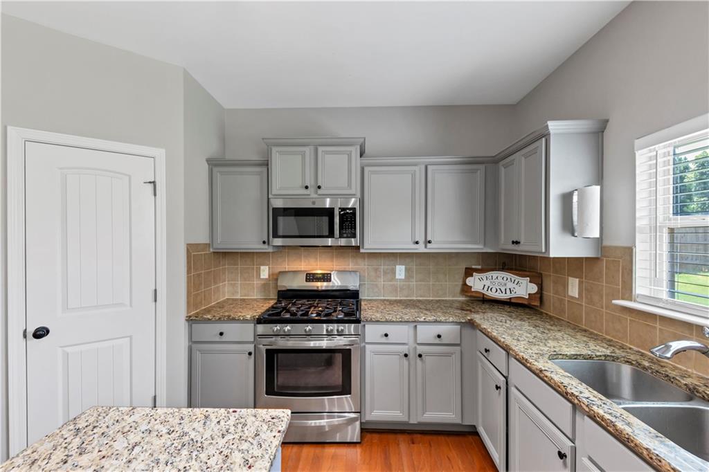 210 Creek View Lane Acworth, GA 30102 - Photo 13 of 48 a kitchen with stainless steel appliances granite countertop a stove a sink and a white cabinets
