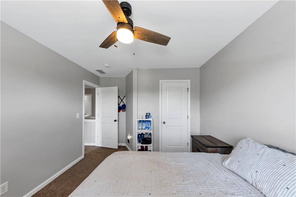 210 Creek View Lane Acworth, GA 30102 - Photo 25 of 48 a bedroom with a large bed and a chandelier