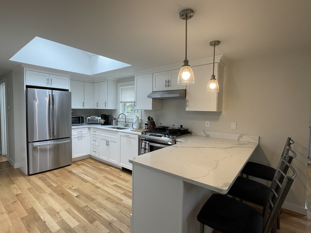 91 Martin Street Wareham, MA 02532 - Photo 8 of 25 a kitchen with stainless steel appliances a stove a sink a refrigerator a center island and cabinets