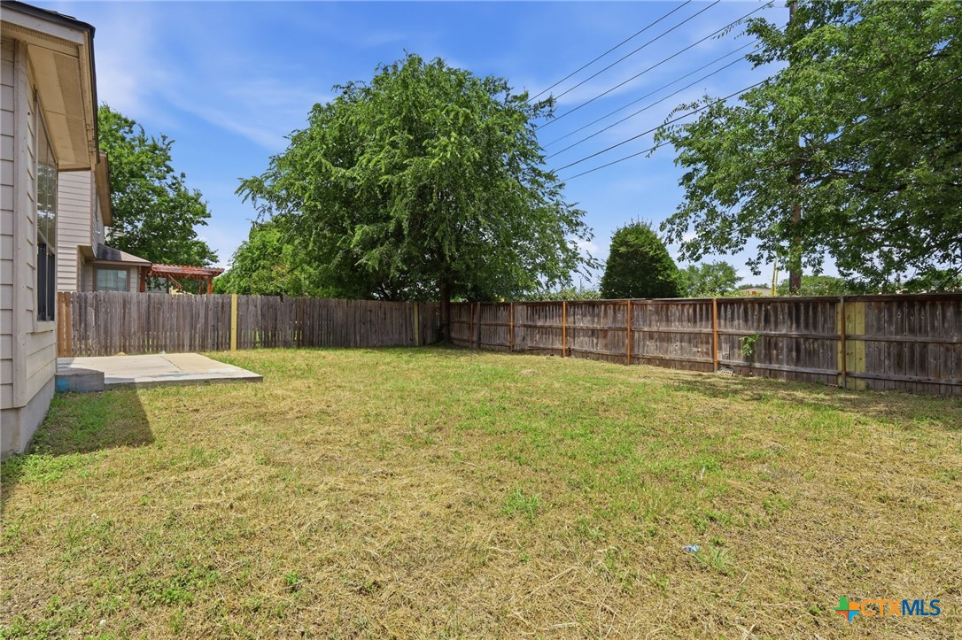 8716 Starview Street Temple, TX 76502 - Photo 31 of 36 Open backyard area with a wooden privacy fence, perfect for pets or play.