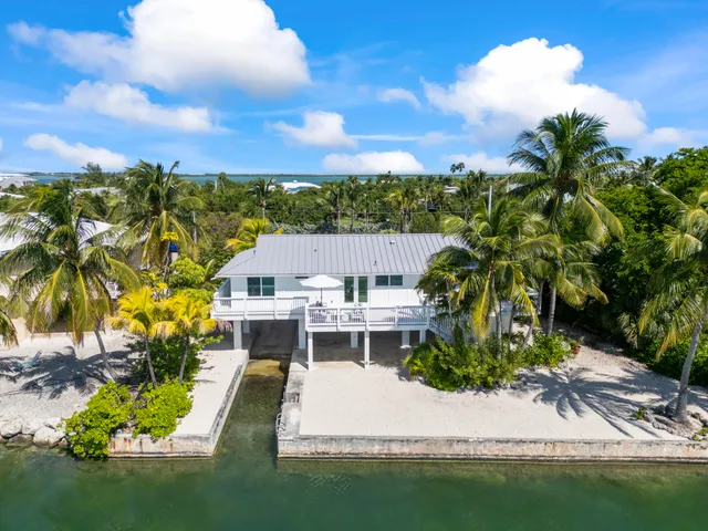 a aerial view of a house with a garden and lake view