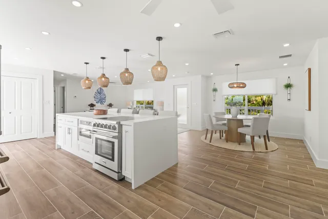 a kitchen with stainless steel appliances kitchen island granite countertop a stove a sink and a refrigerator