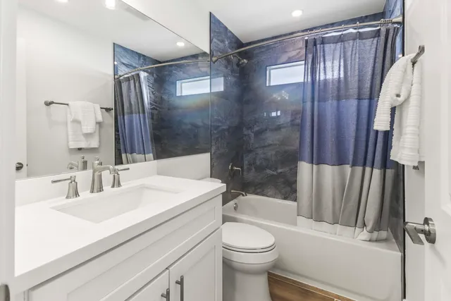 a bathroom with a sink a toilet and shower