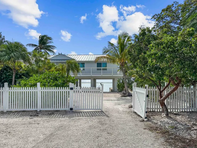 a view of a house with a small yard and wooden fence