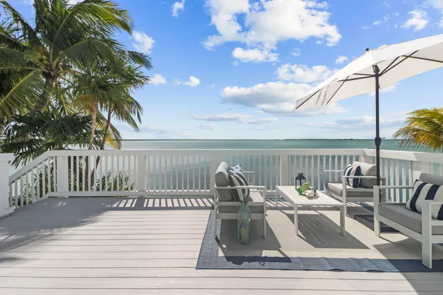 a roof deck with couches and wooden floor