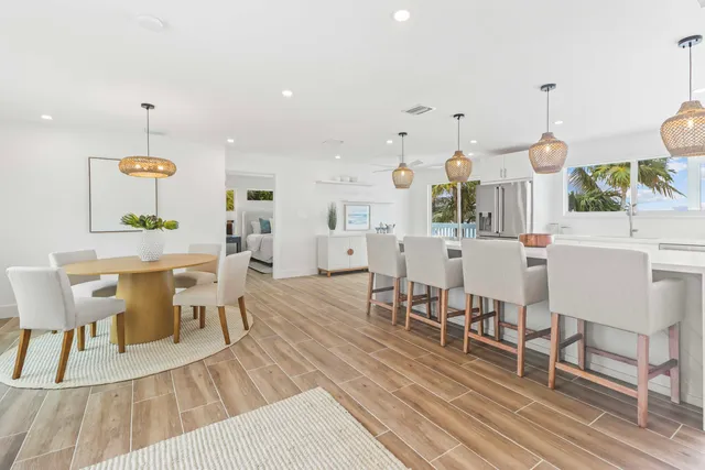 a large white kitchen with a large window a sink and stainless steel appliances