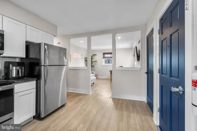 a kitchen with stainless steel appliances a refrigerator and wooden floor