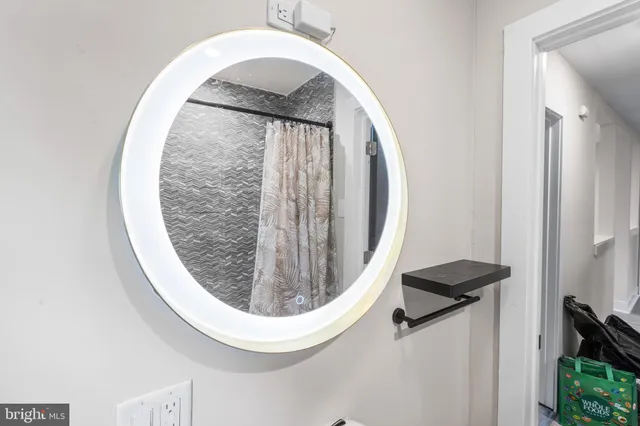 a bedroom with a bed a window and painting on the wall