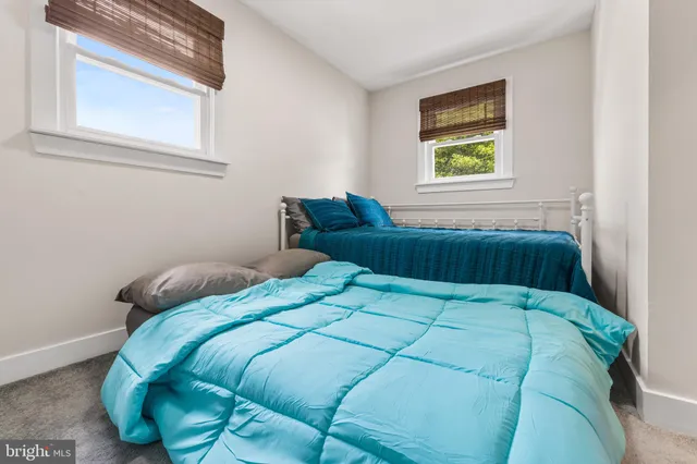 a bedroom with a bed and a lamp on the dresser