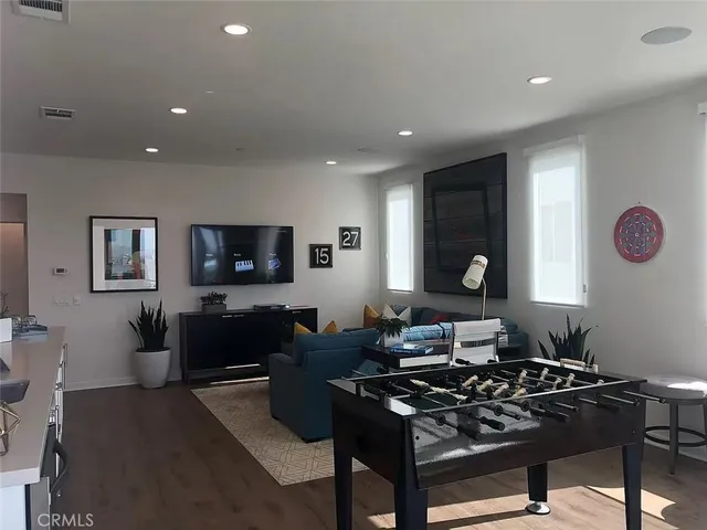 a living room with furniture a flat screen tv and a window