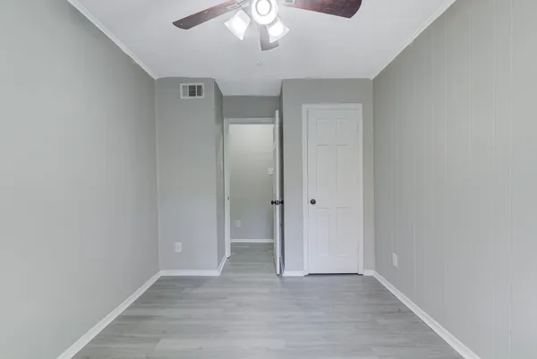 a view of an empty room with wooden floor