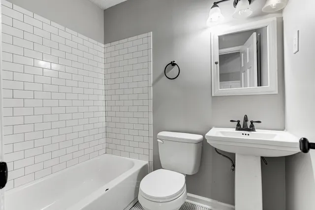 a bathroom with a sink mirror toilet and bathtub
