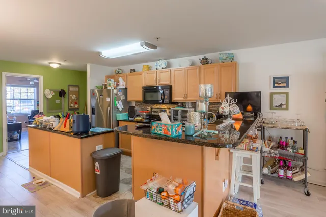 a kitchen with stainless steel appliances granite countertop a refrigerator a stove and a sink with cabinets