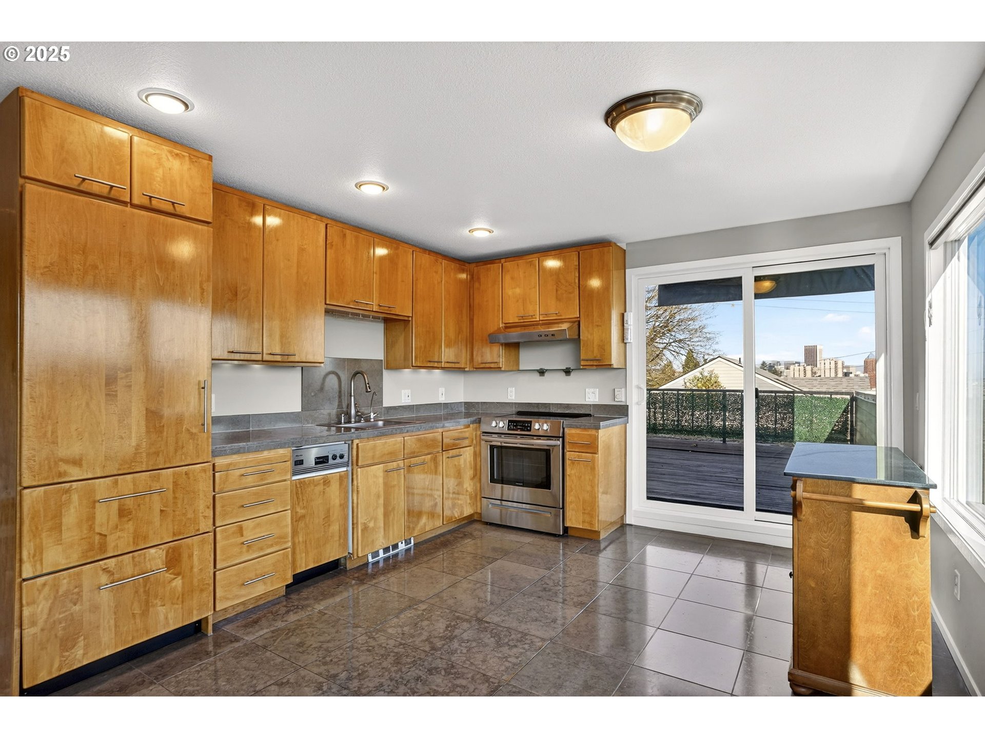 3515 Southwest Barbur Boulevard, Unit R2 Portland, OR 97239 - Photo 14 of 35 a kitchen with stainless steel appliances granite countertop a stove a sink and a refrigerator