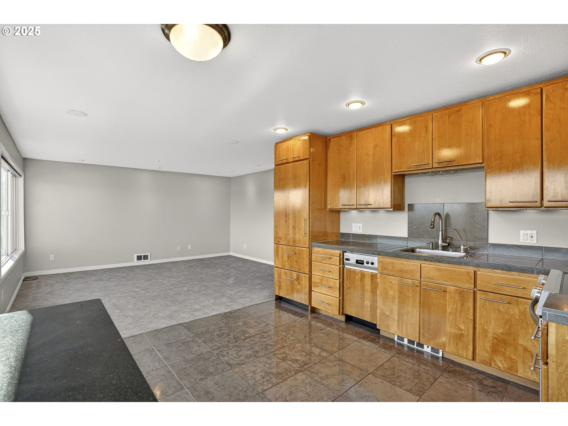 3515 Southwest Barbur Boulevard, Unit R2 Portland, OR 97239 - Photo 16 of 35 a kitchen with stainless steel appliances granite countertop a sink refrigerator stove and white cabinets with wooden floor