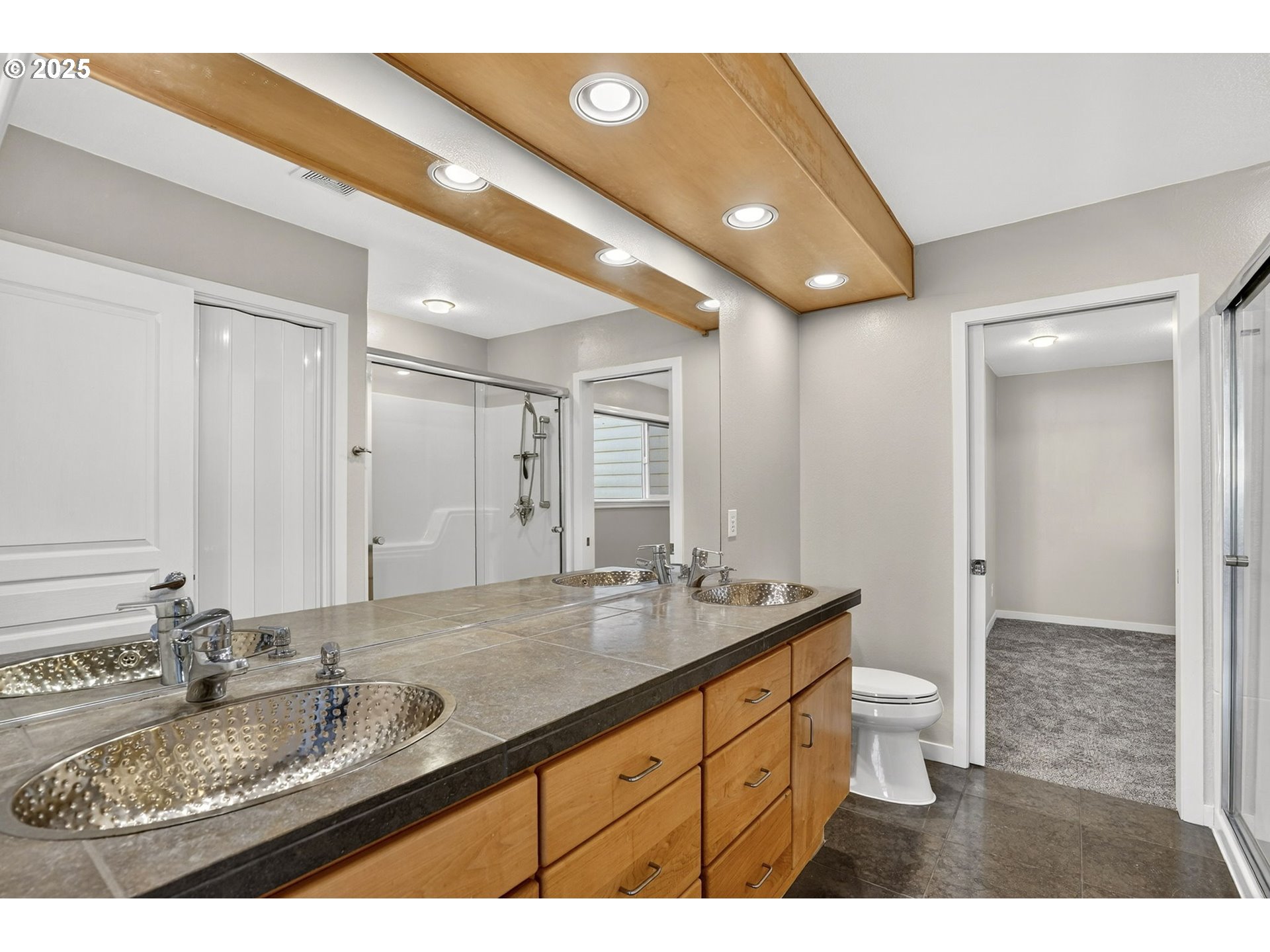 3515 Southwest Barbur Boulevard, Unit R2 Portland, OR 97239 - Photo 23 of 35 a bathroom with a granite countertop sink a large mirror and a shower