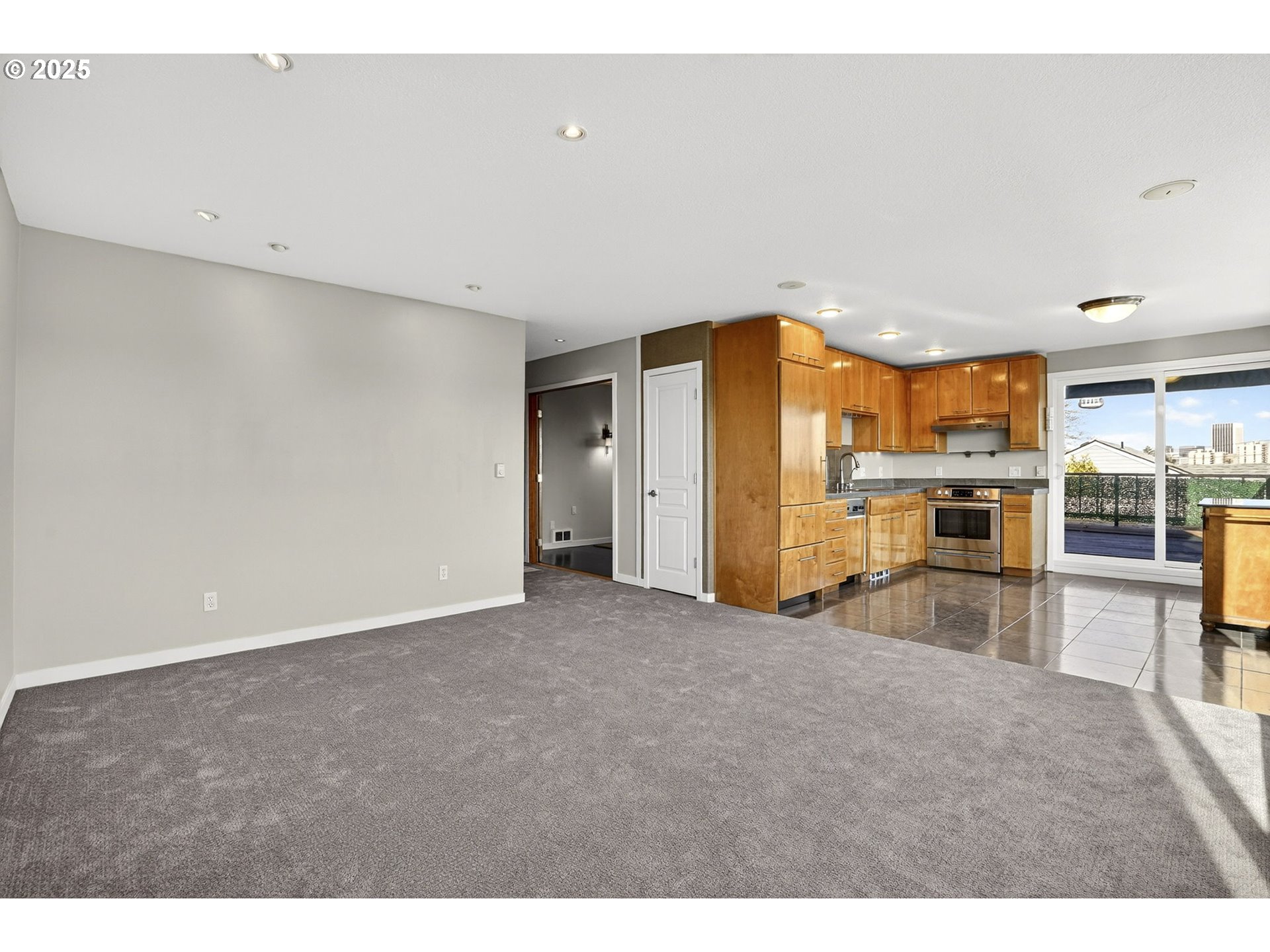 3515 Southwest Barbur Boulevard, Unit R2 Portland, OR 97239 - Photo 10 of 35 a view of a kitchen with a sink wooden cabinets and a refrigerator