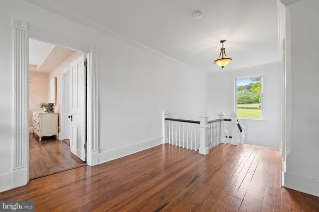 a hallway with front door wooden floor and windows