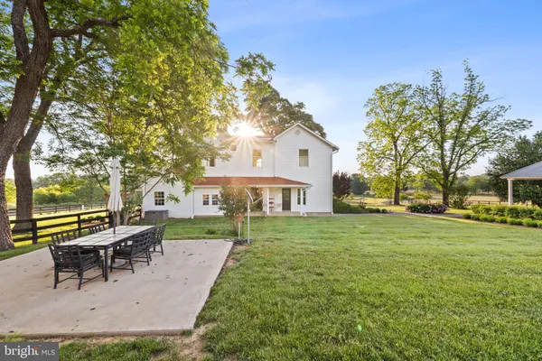 a view of a house with a big yard and large trees