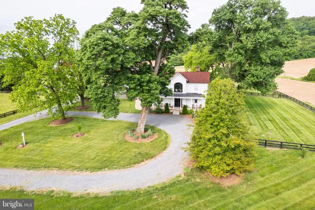 a living room with furniture a fireplace two large windows