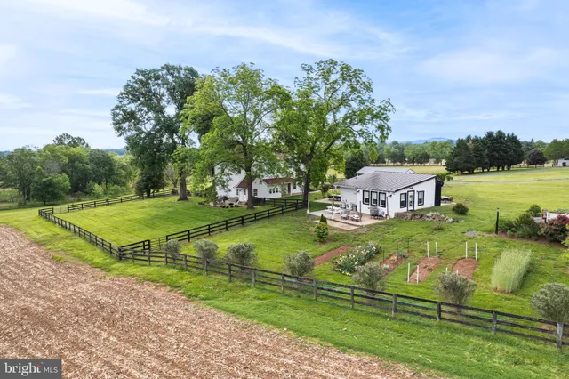 a kitchen with stainless steel appliances granite countertop a stove a refrigerator a sink dishwasher a dining table and chairs with wooden floor