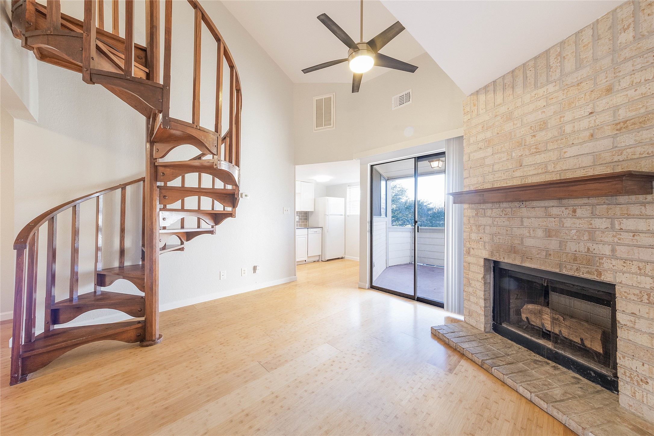 2500 Burleson Road, Unit 512 Austin, TX 78741 - Photo 1 of 16 Unfurnished living room featuring a fireplace, light wood-style flooring, vaulted ceiling, and ceiling fan