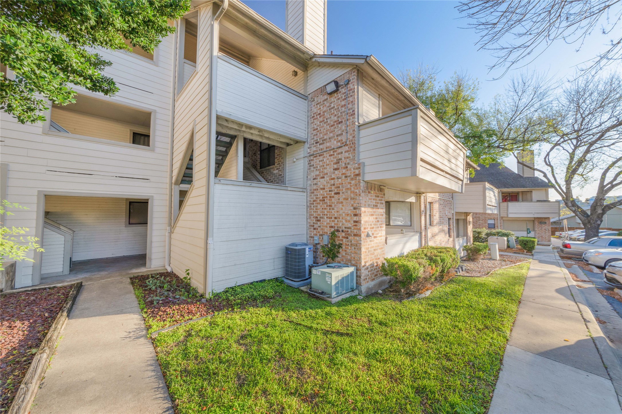 2500 Burleson Road, Unit 512 Austin, TX 78741 - Photo 16 of 16 View of home's exterior with a balcony, brick siding, and a chimney