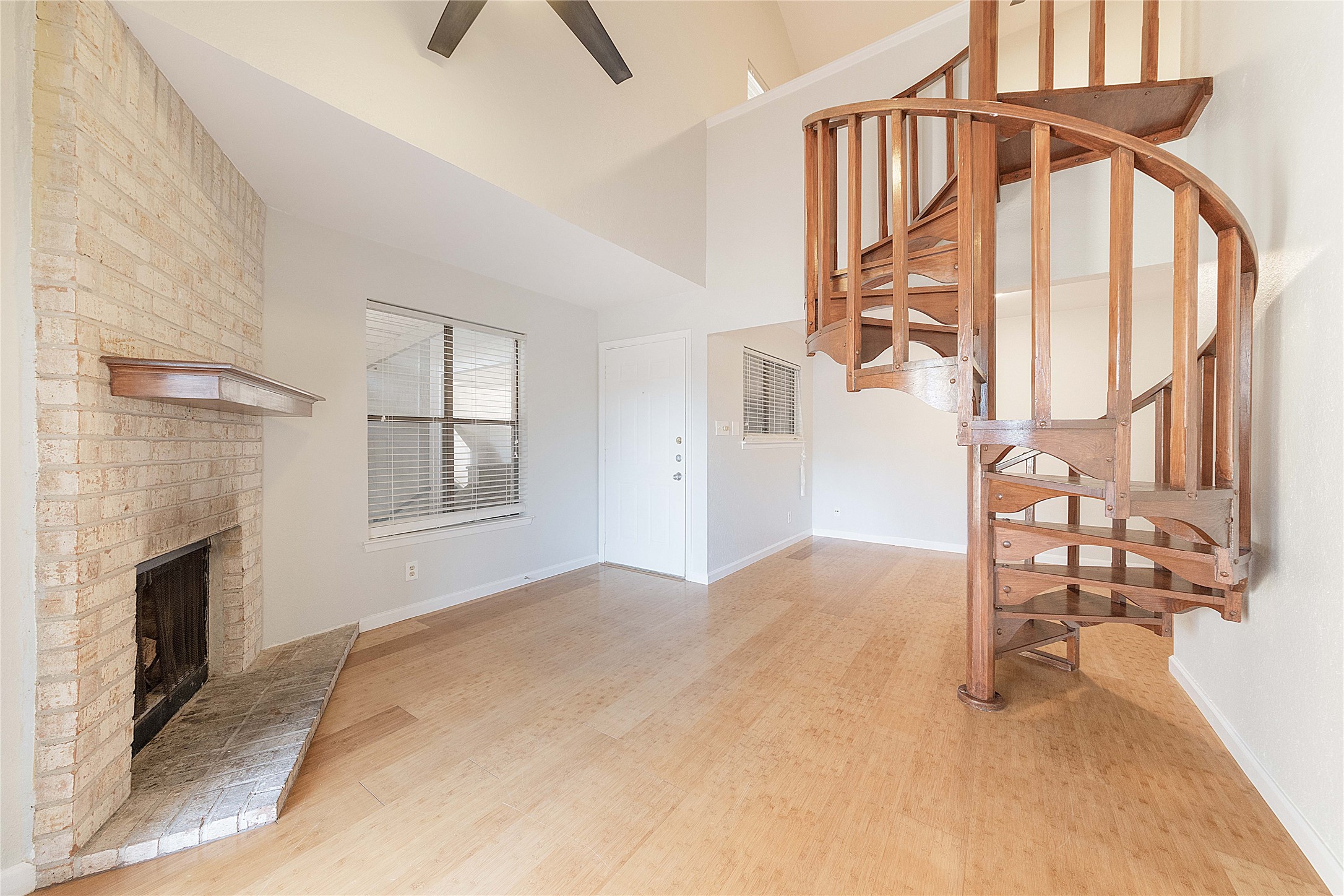 2500 Burleson Road, Unit 512 Austin, TX 78741 - Photo 7 of 16 Unfurnished living room with a high ceiling, light wood-style flooring, a brick fireplace, and a ceiling fan