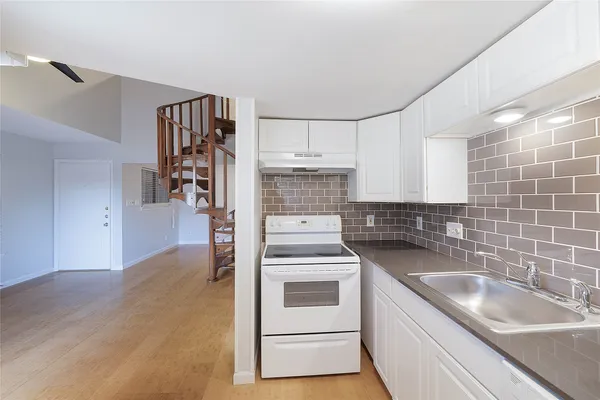 a kitchen with a sink a refrigerator and cabinets