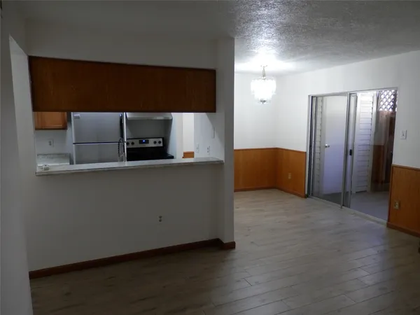 a view of kitchen with stainless steel appliances granite countertop cabinets and wooden floor