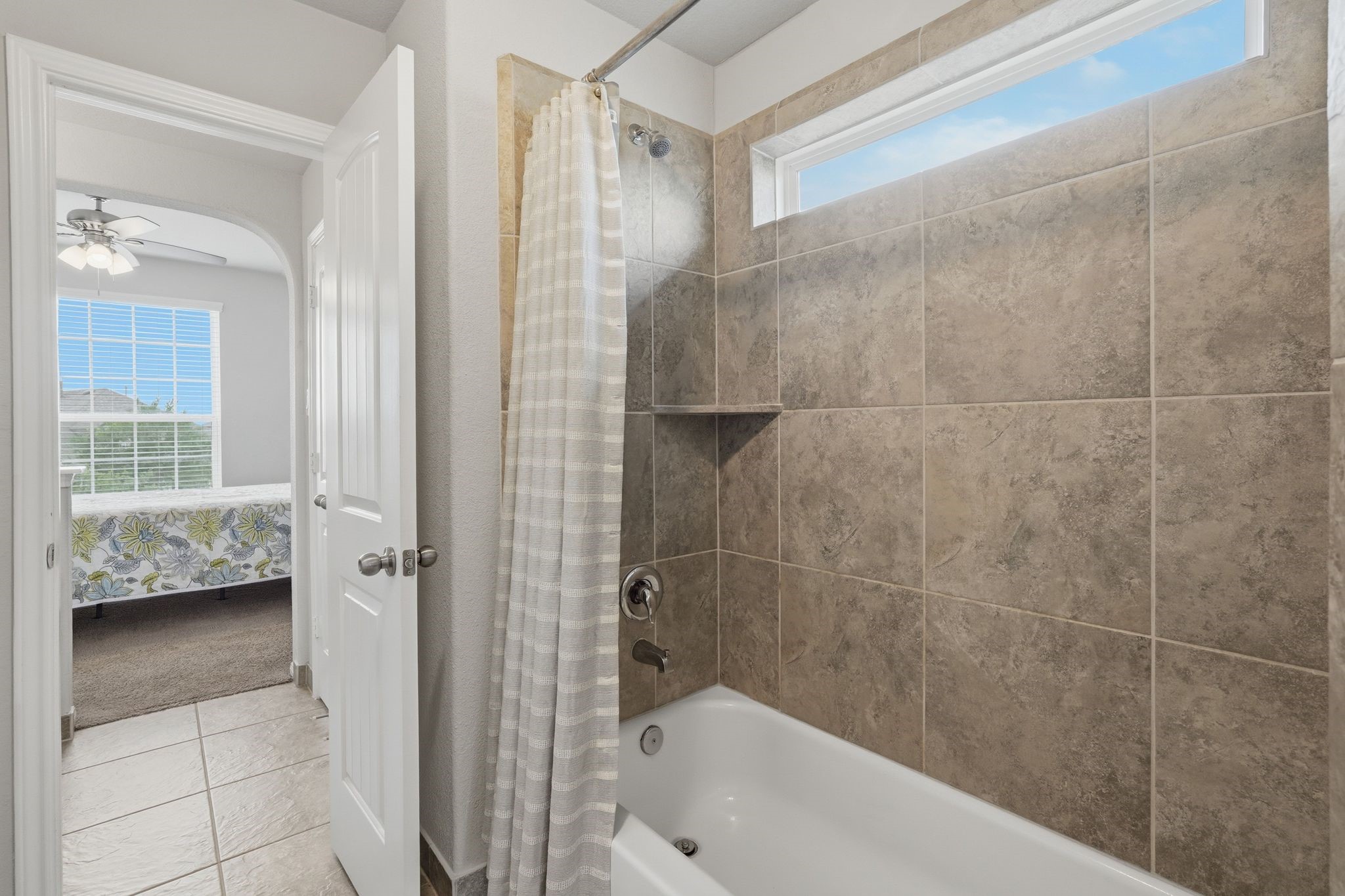 7522 Windsor View Drive Spring, TX 77379 - Photo 38 of 49 Fresh and polished bathroom with full tile surround and a bright window above the tub.