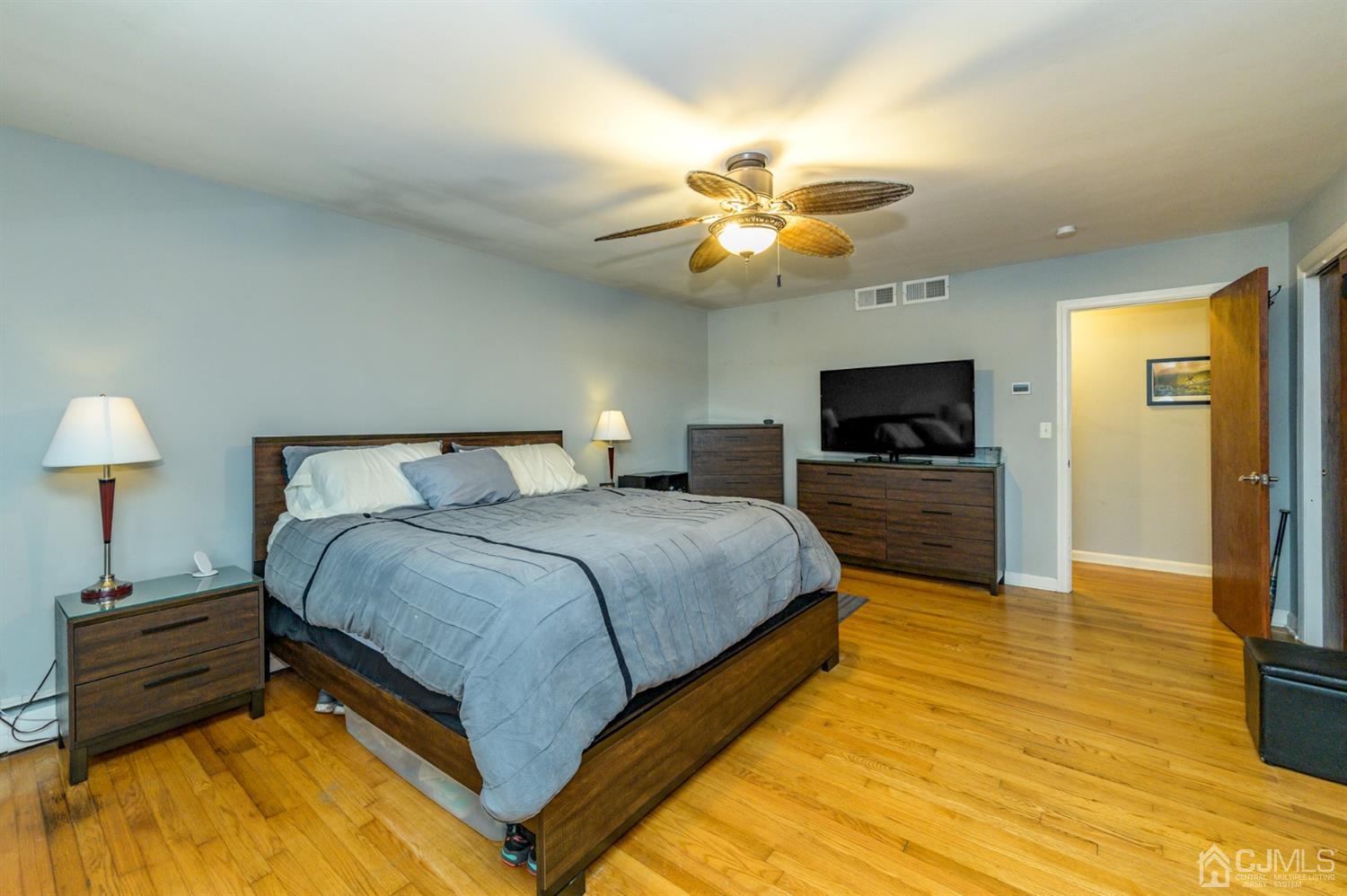 1727 River Road Belmar, NJ 07719 - Photo 22 of 38 a spacious bedroom with a bed and a flat screen tv