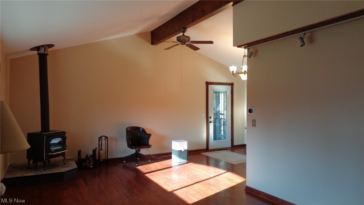 10157 Ravenna Road Chardon, OH 44024 - Photo 33 of 34 Living room featuring beam ceiling, dark wood-type flooring, high vaulted ceiling, ceiling fan with notable chandelier, and a wood stove