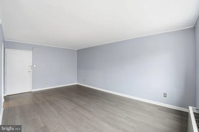 a view of an empty room with wooden floor