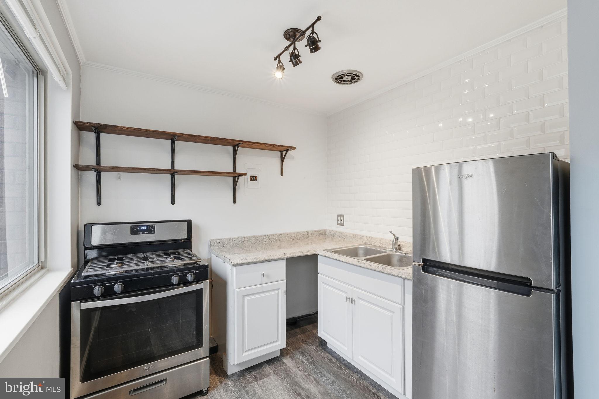 2710 Macomb Street Northwest, Unit 207 Washington, DC 20008 - Photo 2 of 32 a kitchen with a stove sink and refrigerator