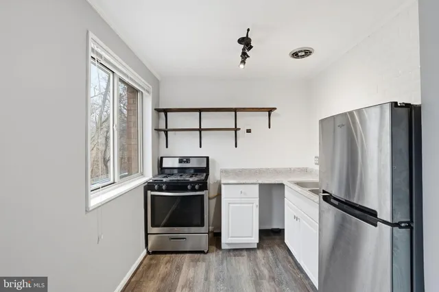 a kitchen with stainless steel appliances a refrigerator and a stove top oven
