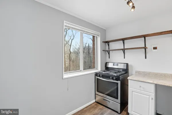 a kitchen with granite countertop cabinets stainless steel appliances and a window