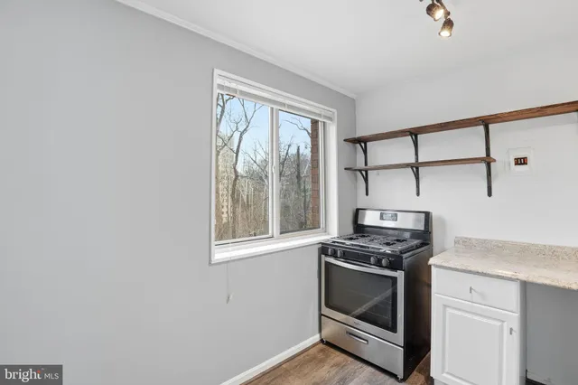 a kitchen with granite countertop cabinets stainless steel appliances and a window