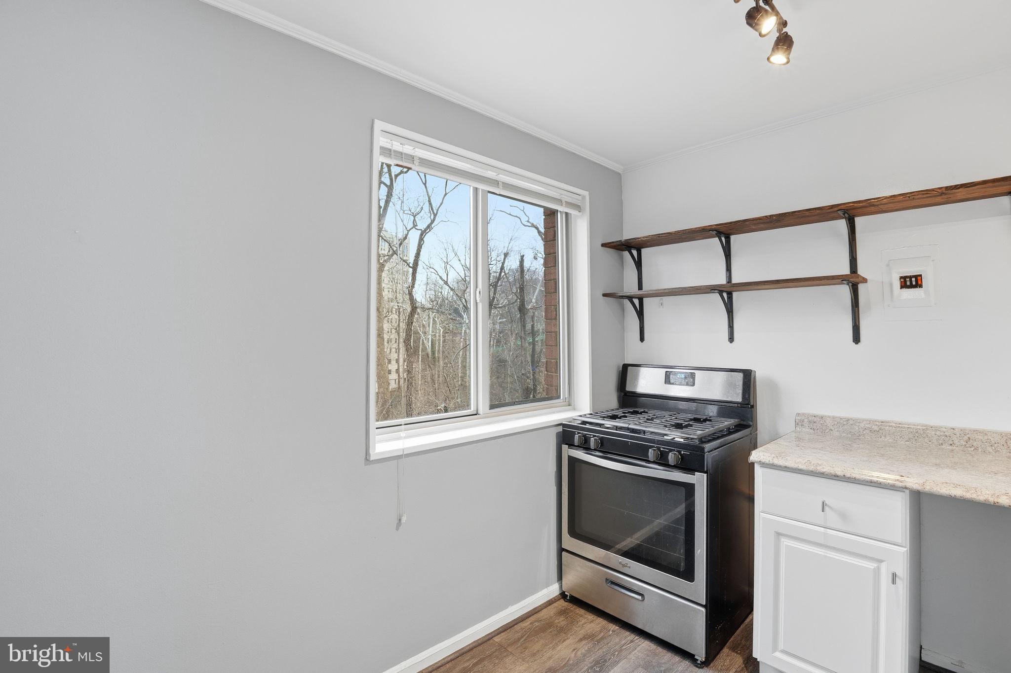2710 Macomb Street Northwest, Unit 207 Washington, DC 20008 - Photo 4 of 32 a kitchen with granite countertop cabinets stainless steel appliances and a window