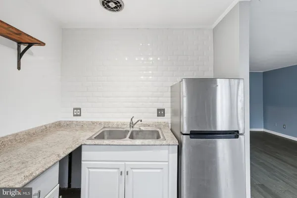 a kitchen with a refrigerator and a sink