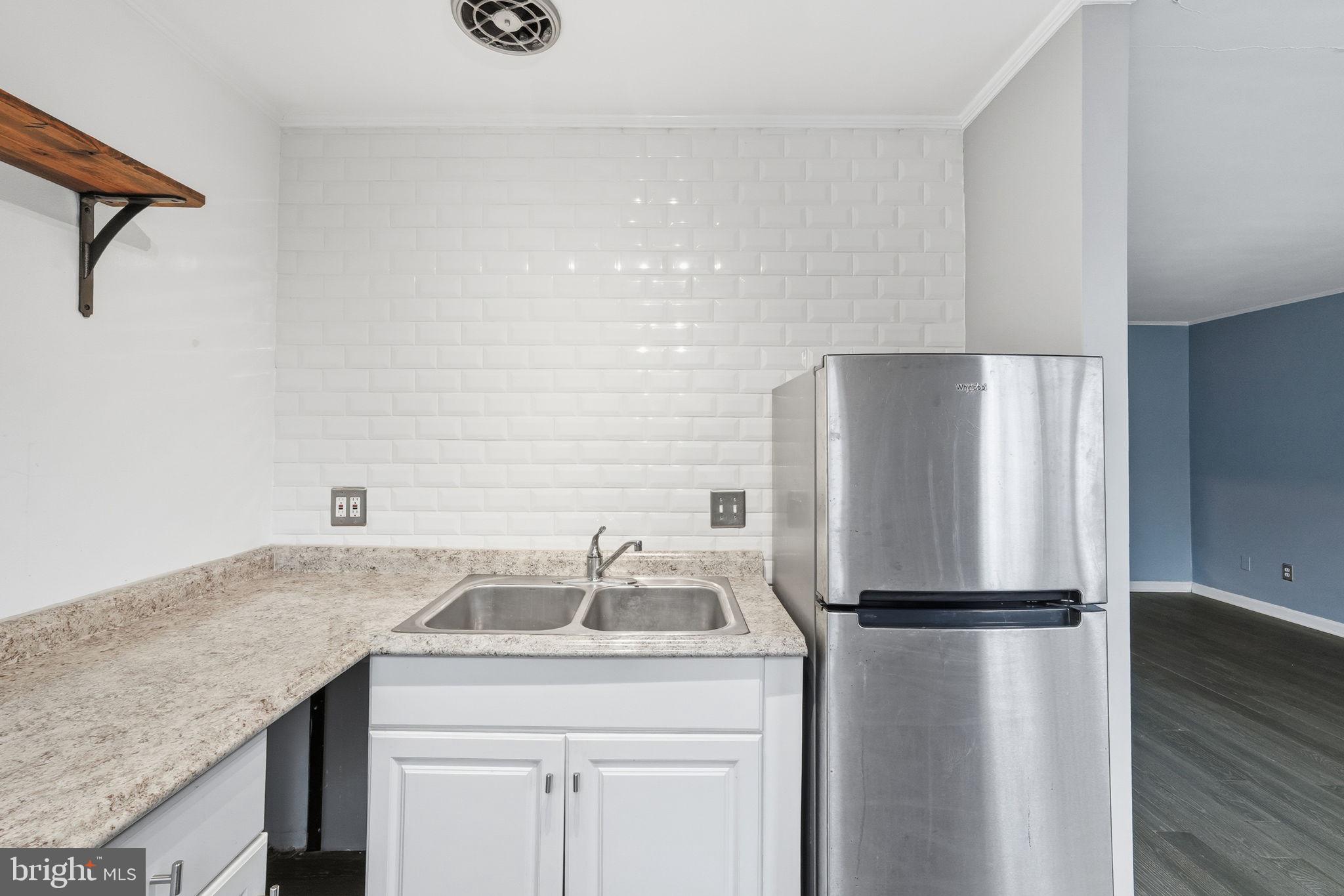 2710 Macomb Street Northwest, Unit 207 Washington, DC 20008 - Photo 5 of 32 a kitchen with a refrigerator and a sink