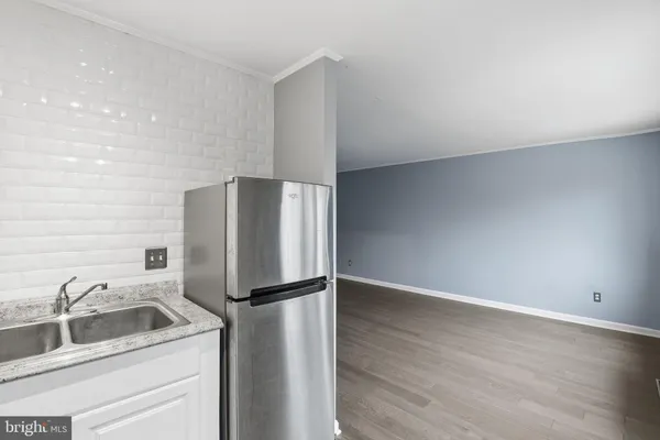 a kitchen with a refrigerator sink and cabinets