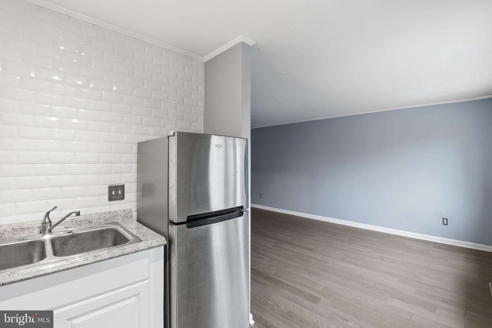 2710 Macomb Street Northwest, Unit 207 Washington, DC 20008 - Photo 6 of 32 a kitchen with a refrigerator sink and cabinets