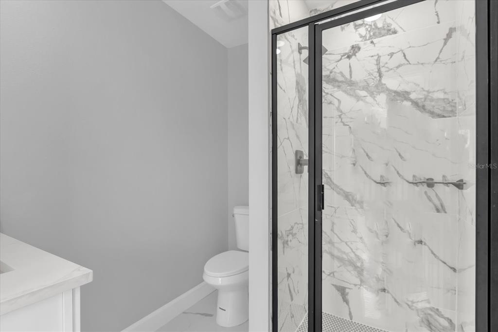 2404 Center Street Sanford, FL 32771 - Photo 19 of 29 a bathroom with a granite countertop shower and a toilet