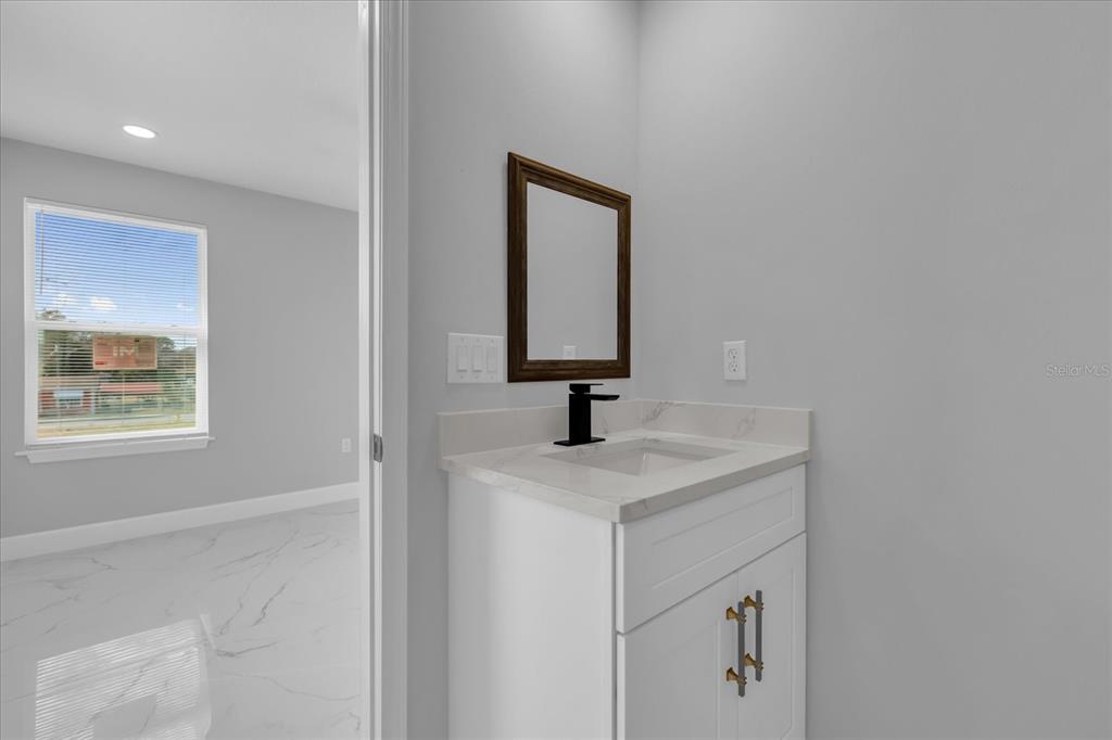 2404 Center Street Sanford, FL 32771 - Photo 20 of 29 a bathroom with a sink a vanity and mirror