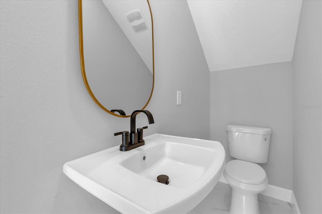 2404 Center Street Sanford, FL 32771 - Photo 21 of 29 a bathroom with a sink a toilet and a mirror