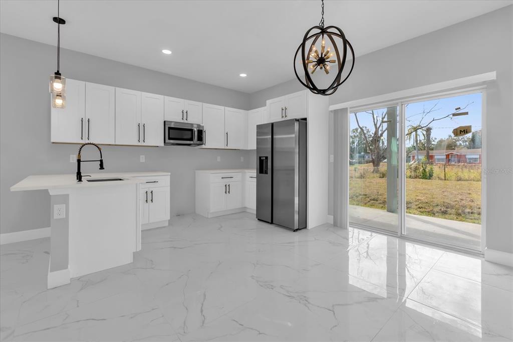 2404 Center Street Sanford, FL 32771 - Photo 4 of 29 a view of kitchen with stainless steel appliances granite countertop a refrigerator a stove a sink and a dining table with wooden floor
